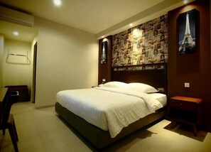 Un dormitorio con cama, escritorio y pared decorada con diversos objetos.