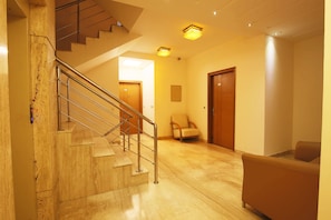 A staircase with metal railings leading to a landing. - FabHotel GRD DLF Square (Gurugram)