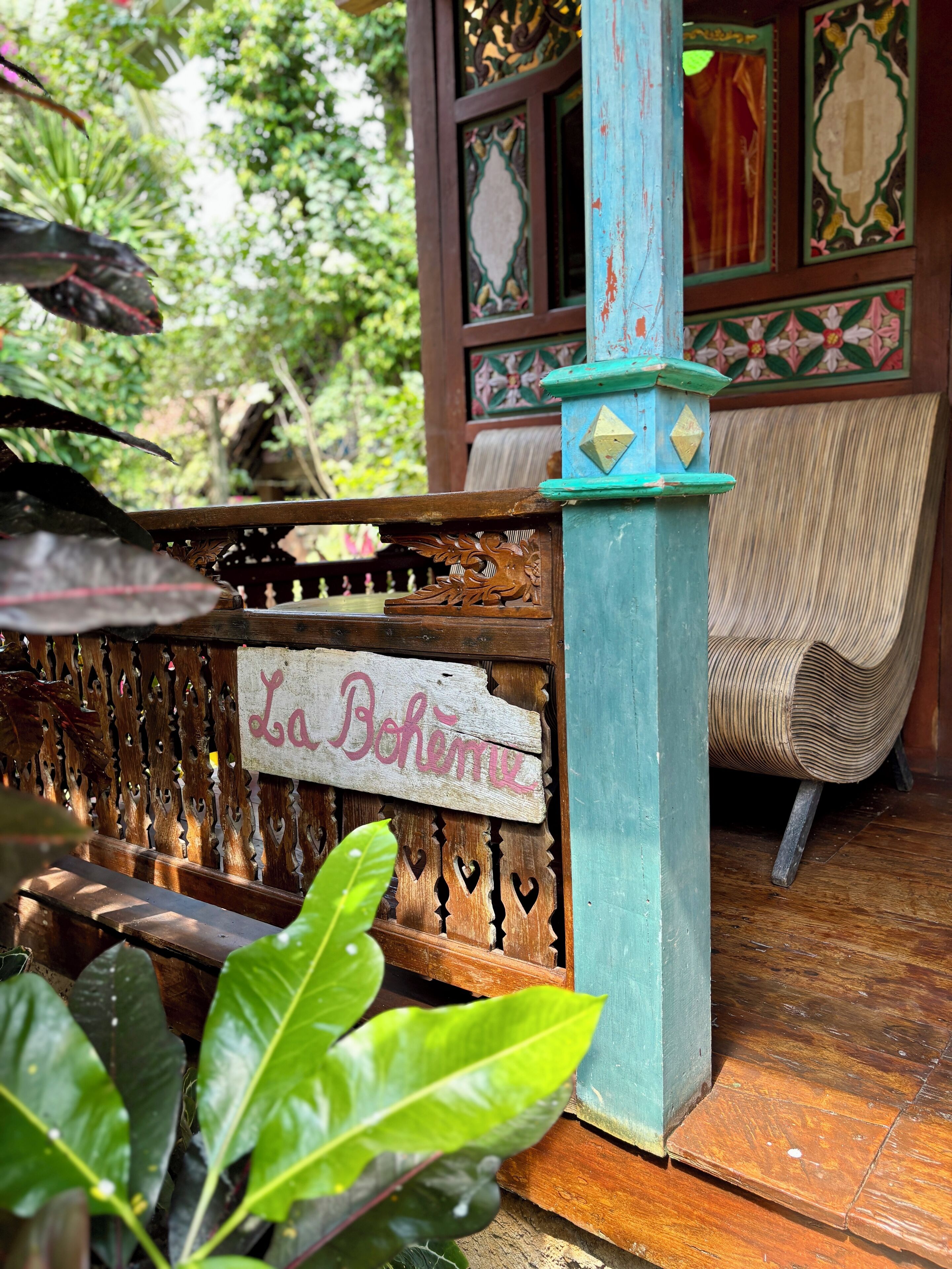 A wooden bench with a sign that reads "La Bohème" in a rustic outdoor setting.