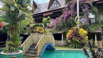 Una piscina al aire libre, sillones reclinables de piscina