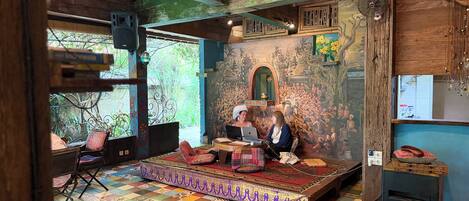 A room with a colorful tiled floor, a wooden ceiling, and a mural on the wall.