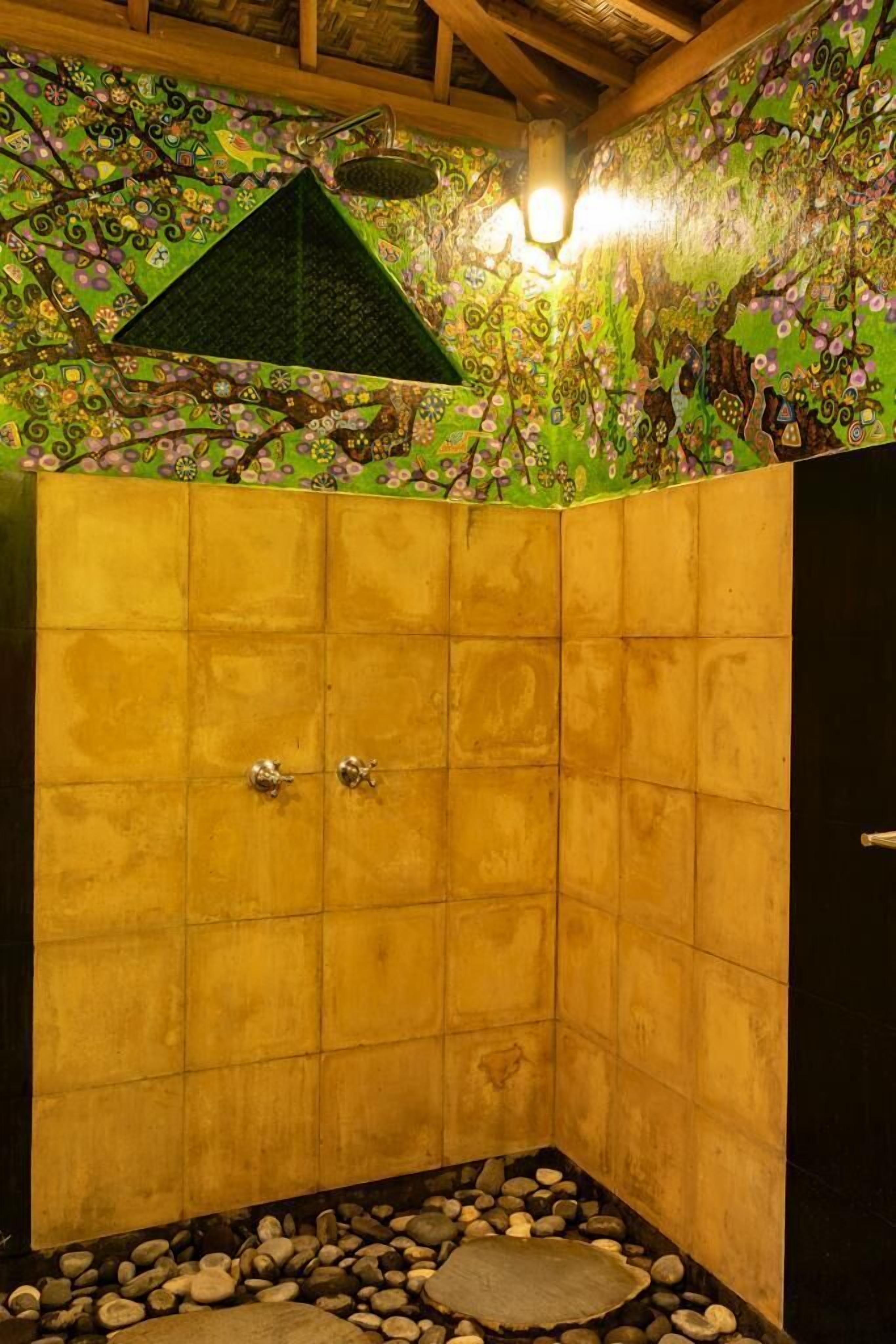 A shower area with tiled walls and a decorative ceiling.