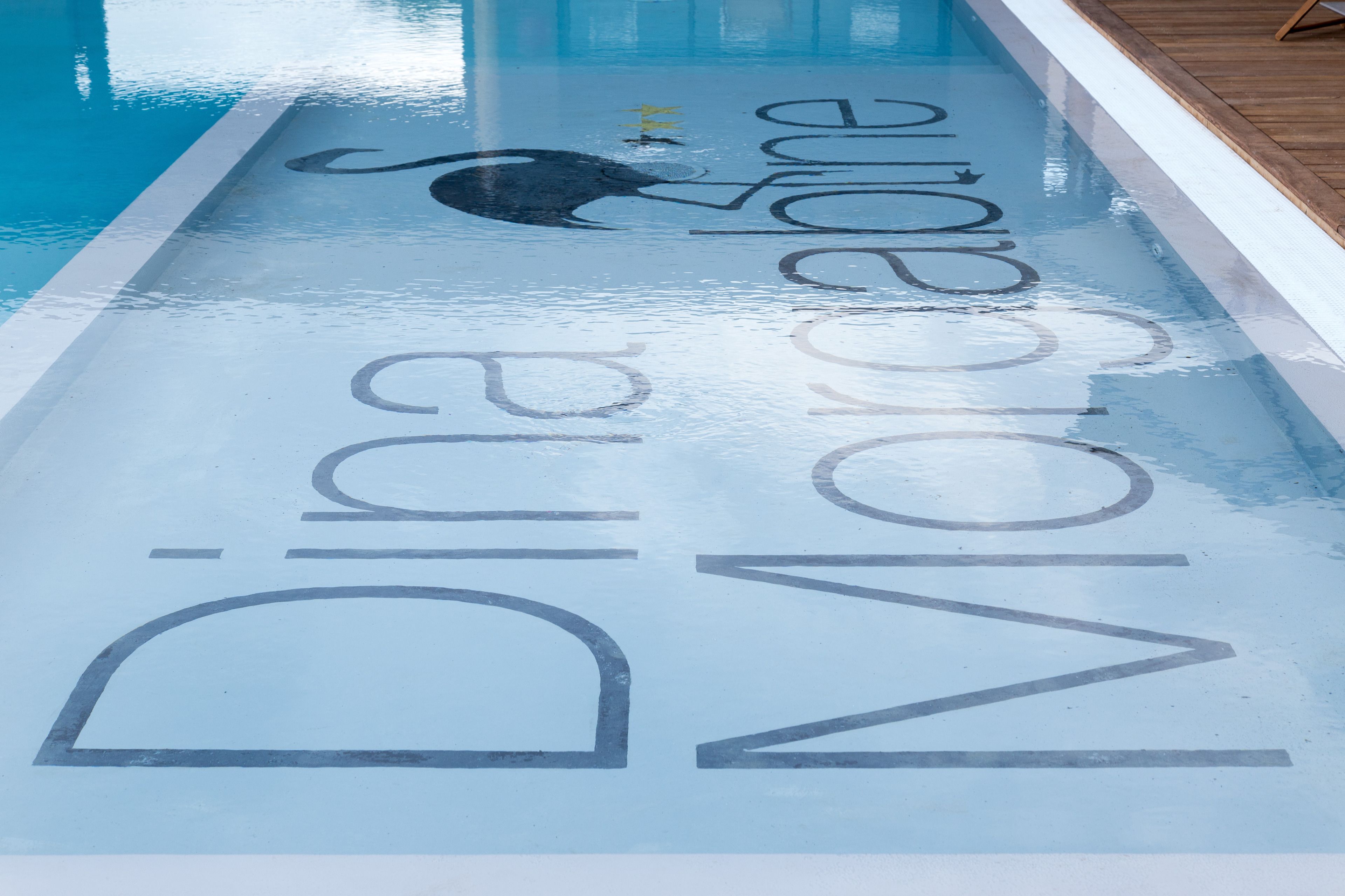 Una piscina con las palabras "Dina Monore" pintadas en la superficie.