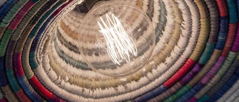 Una estructura circular tejida con una lámpara en el centro.