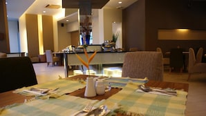 A dining area with a table set for two, a buffet in the background, and a modern interior design.
