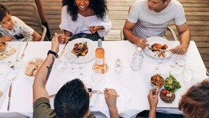 A family dining at a table with various dishes, glasses, and a bottle of water. - Le Saint Pierre Hotel (Saint-Pierre)