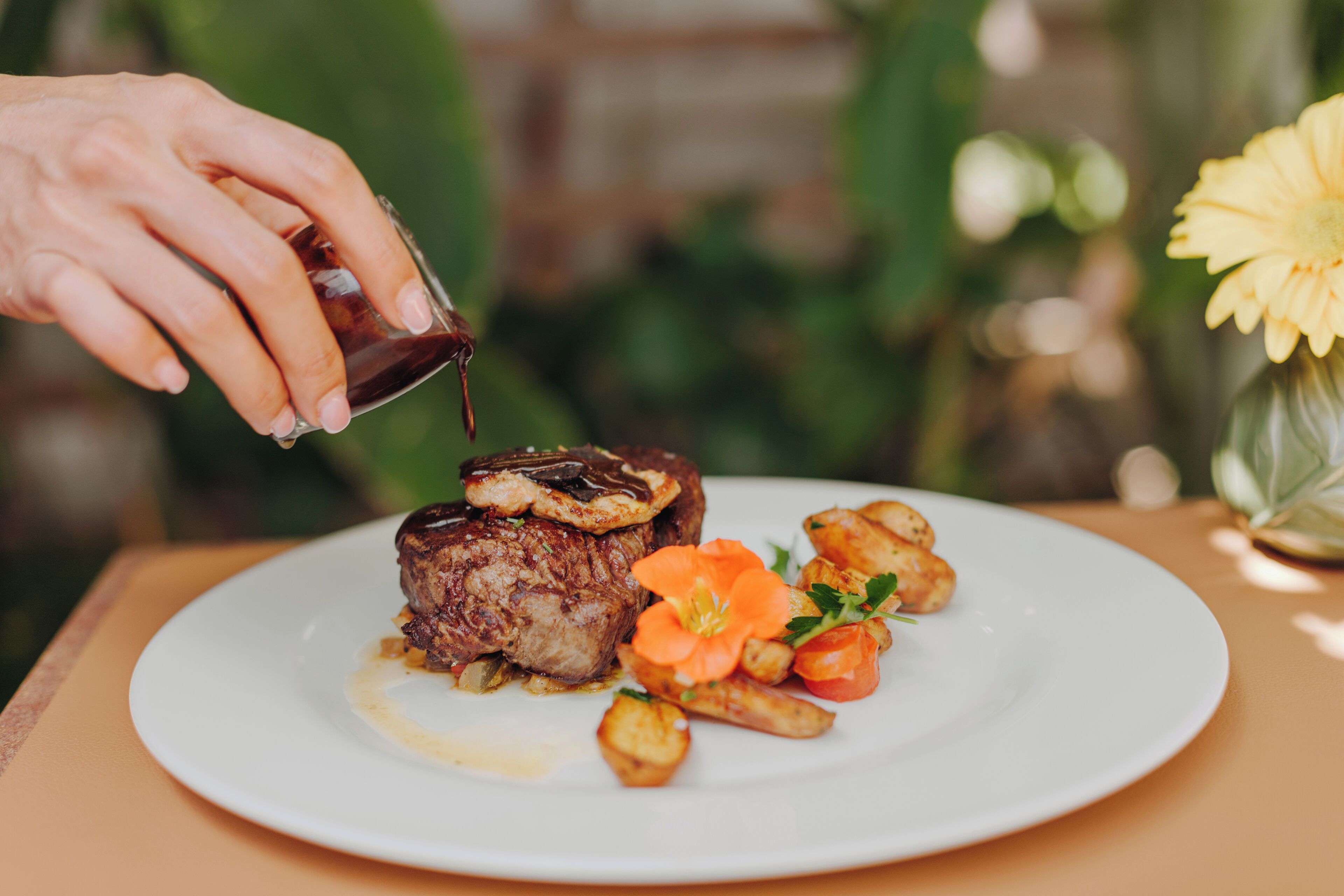 Ein Teller mit einem Steak, Gemüse und Sauce.