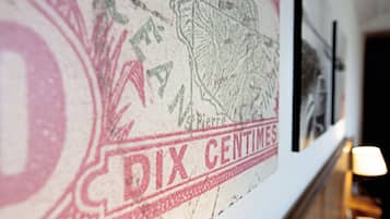 A close-up of a wall with a vintage stamp and a framed picture.