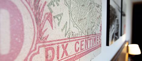 A close-up of a wall with a vintage stamp and a framed picture.