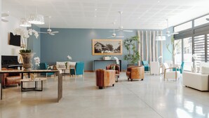A spacious living room with a piano, sofas, and a large window offering a view. - Le Saint Pierre Hotel (Saint-Pierre)