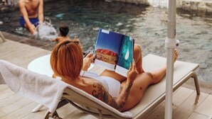 A person relaxing on a sun lounger by a pool, reading a book. - Le Saint Pierre Hotel (Saint-Pierre)
