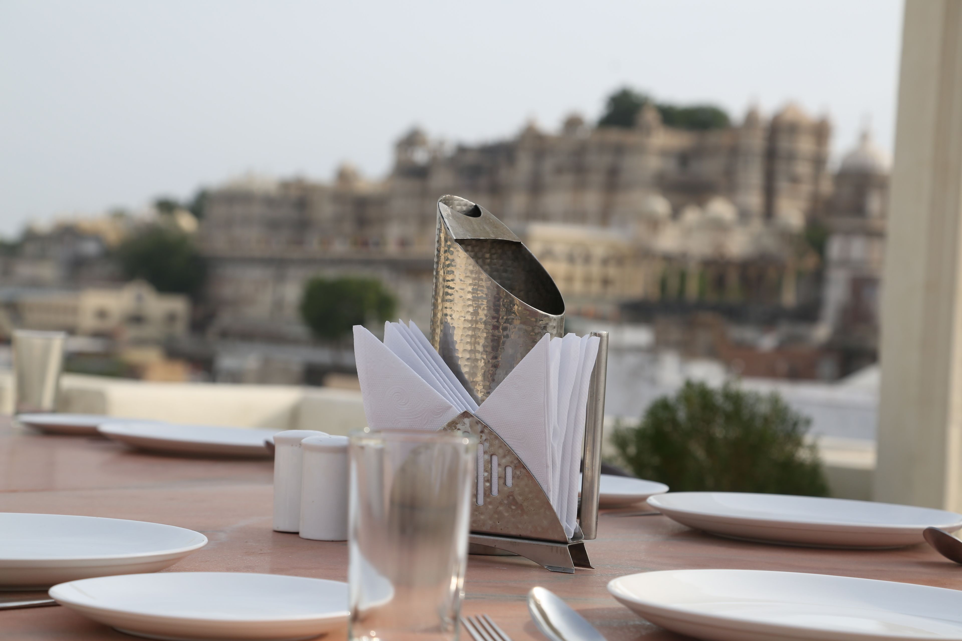 Mesa lista para comer con vista a un paisaje urbano.