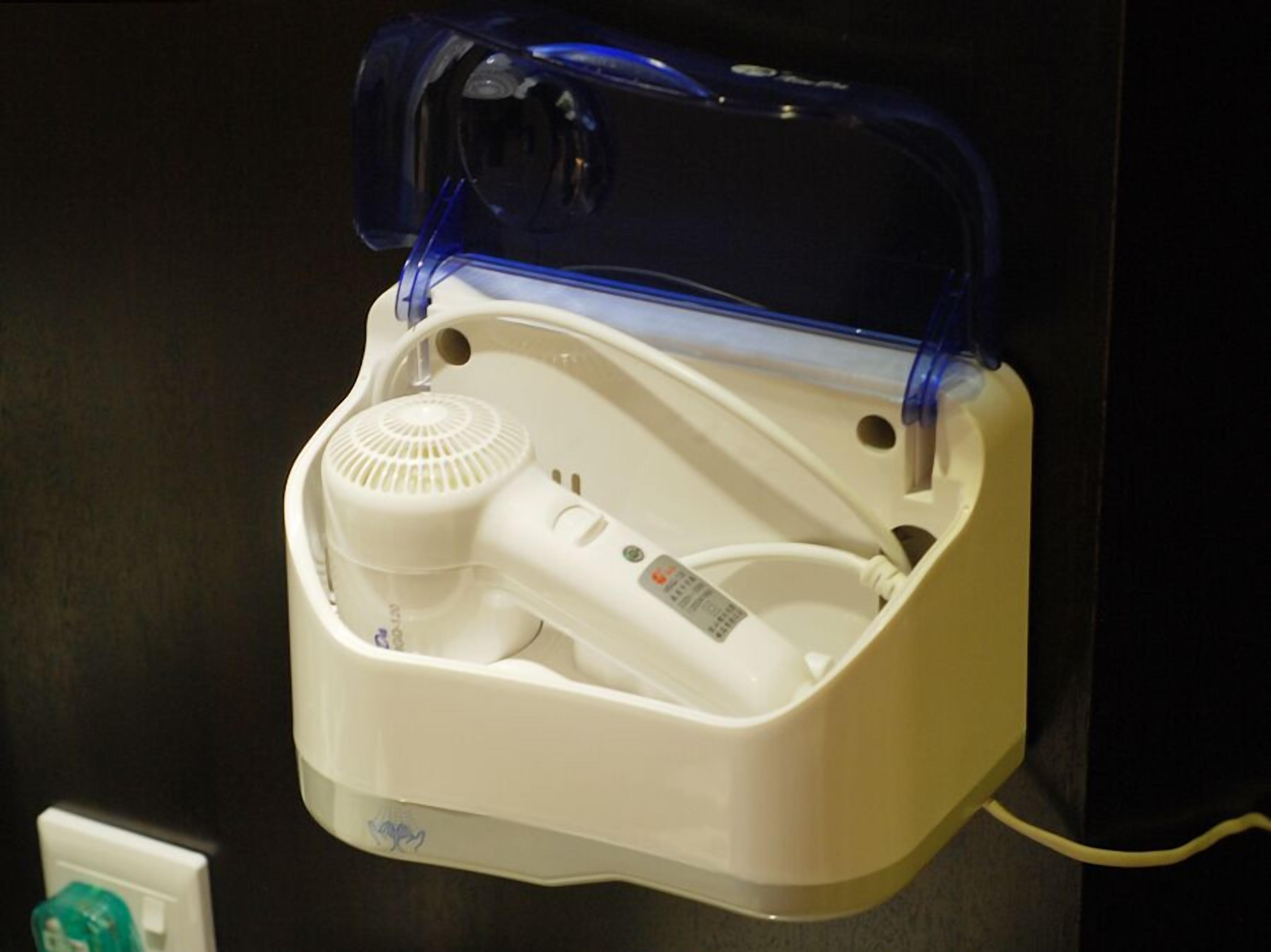 A compact, white portable heater with a digital control panel and a power cord.