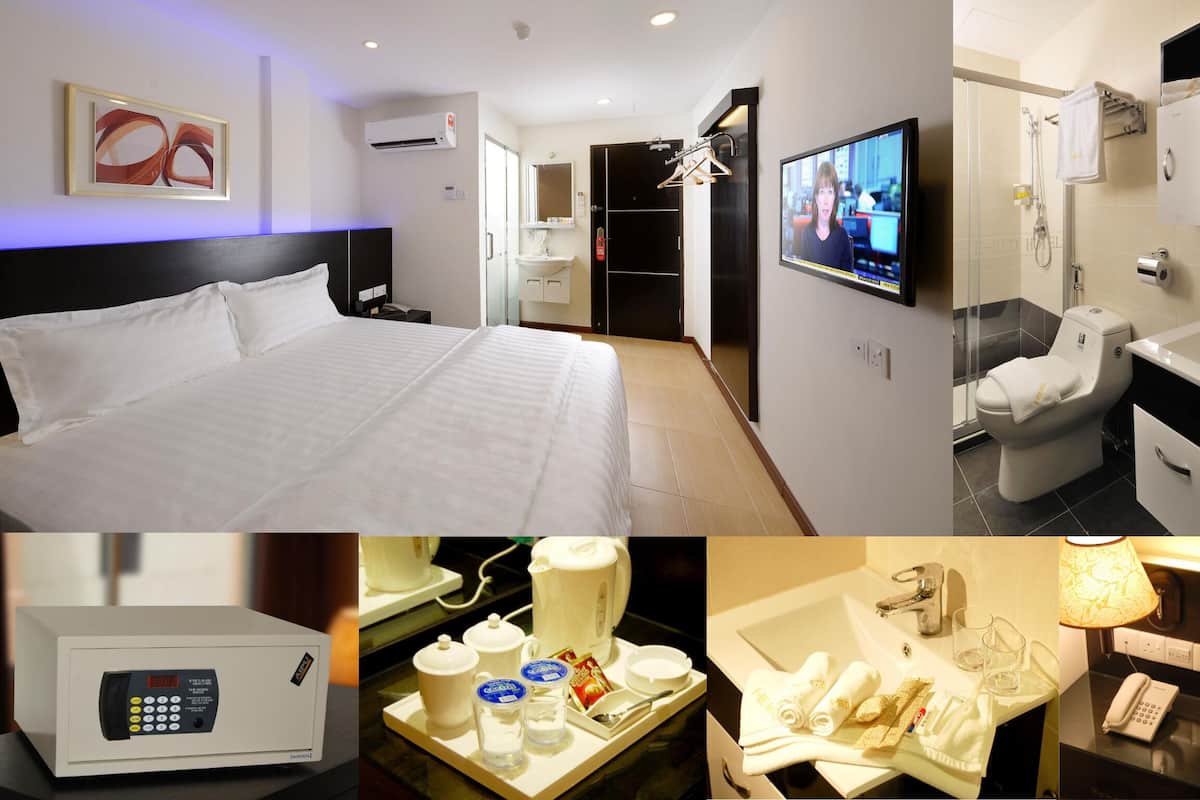 Une chambre d’hôtel comprenant un lit, une télévision, une salle de bain avec douche et un mini-bar.