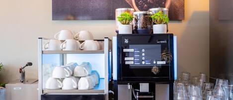 Eine Kaffeestation mit einer Kaffeemaschine, Tassen und einer Kaffeebohnenausstellung.