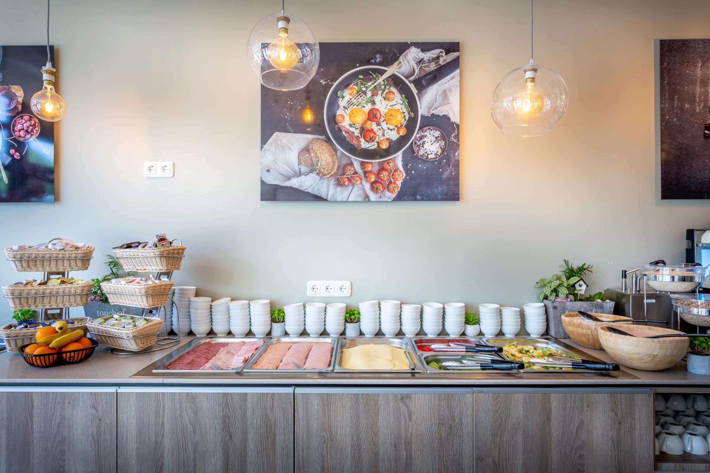 A buffet setup with various food items and serving utensils.