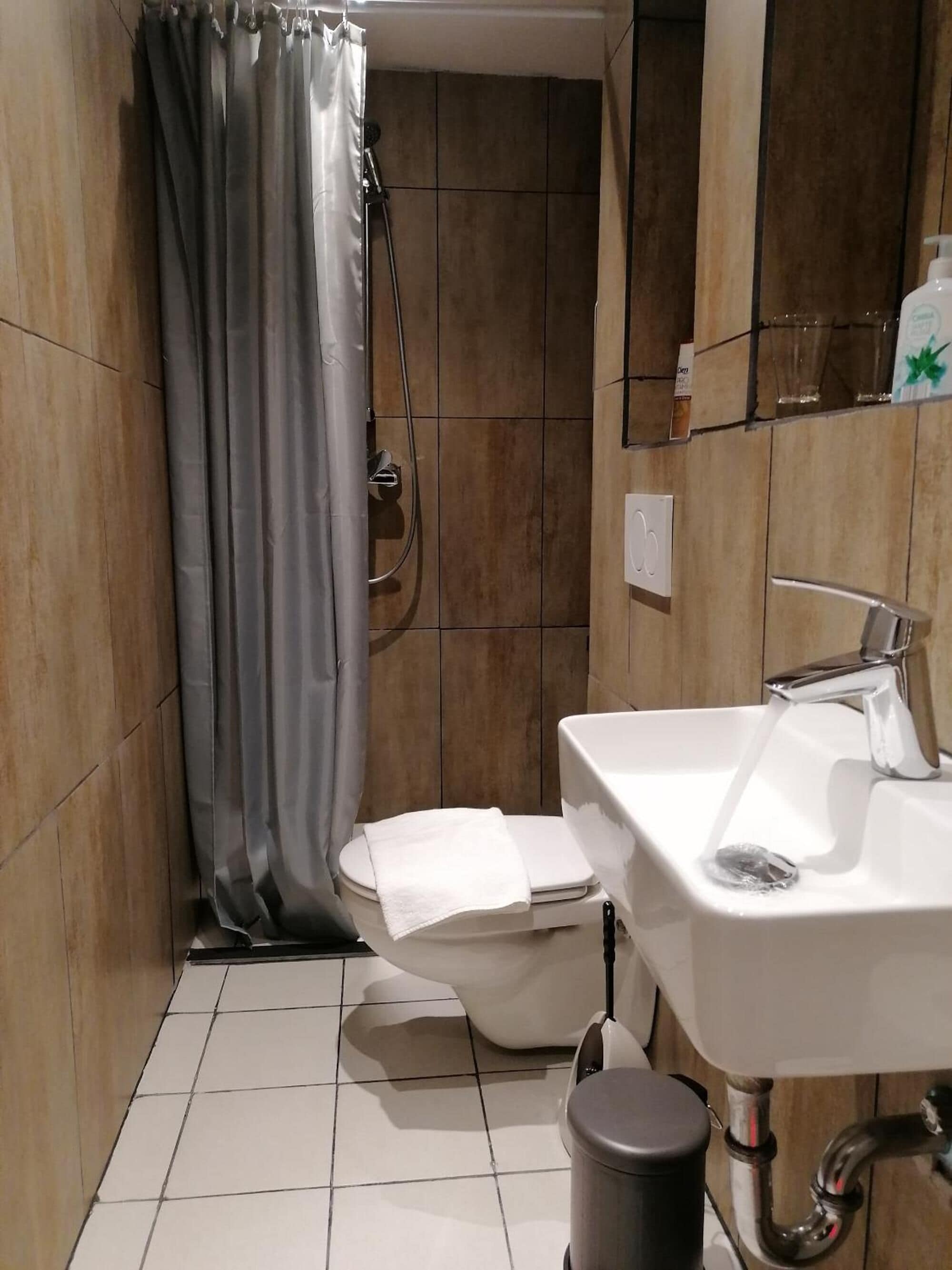 A bathroom with a toilet, sink, and shower.