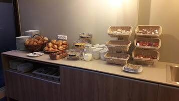 Una mesa de buffet con diferentes alimentos y utensilios.