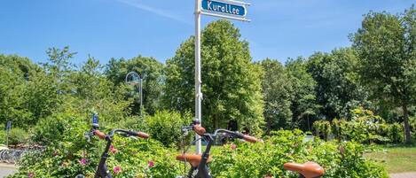 Two bicycles parked next to a signpost with directions to Kyllpork, Hotel en Port, and Kurollee.