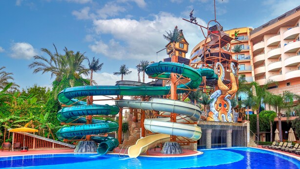 Parque acuático con múltiples toboganes y una piscina.