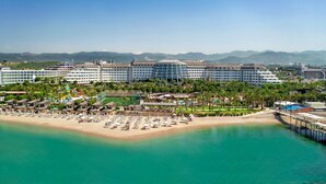 Un resort con varias edificaciones hoteleras, una playa y un parque acuático.
