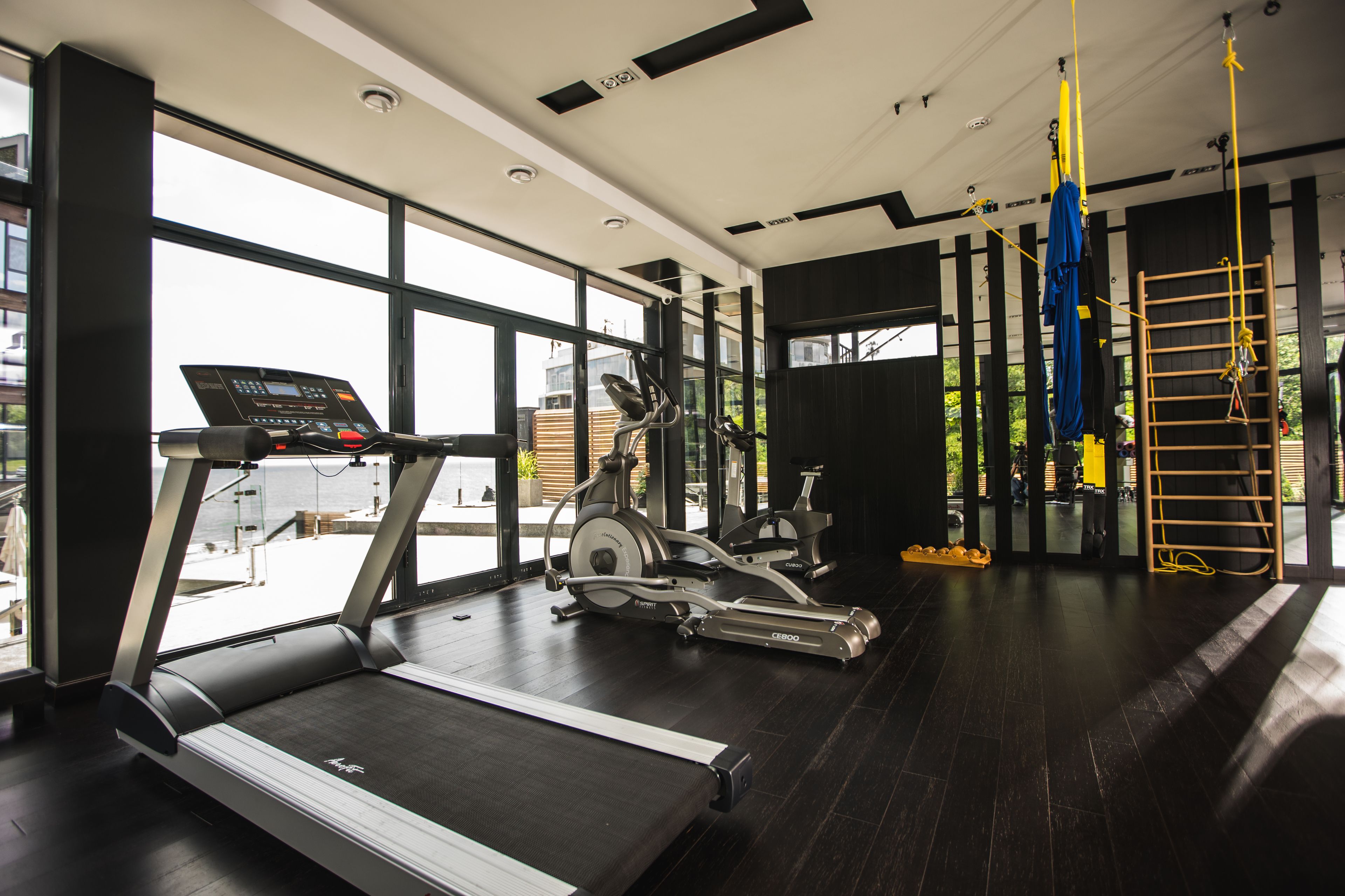 Un gimnasio con cintas de correr, elípticas y una barra de dominadas.