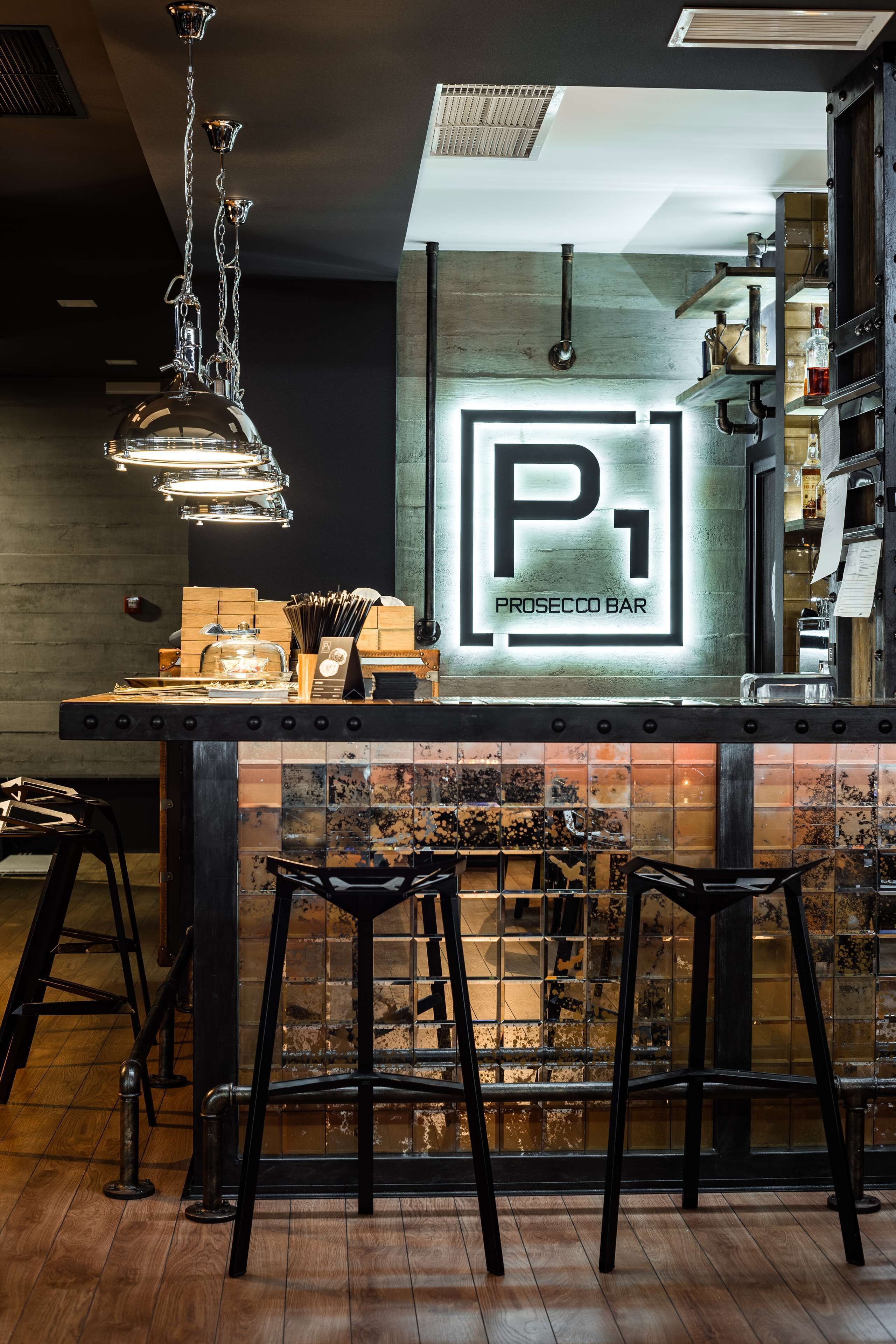 A bar area with a sign reading "PROSECCO BAR" and a tiled backsplash.