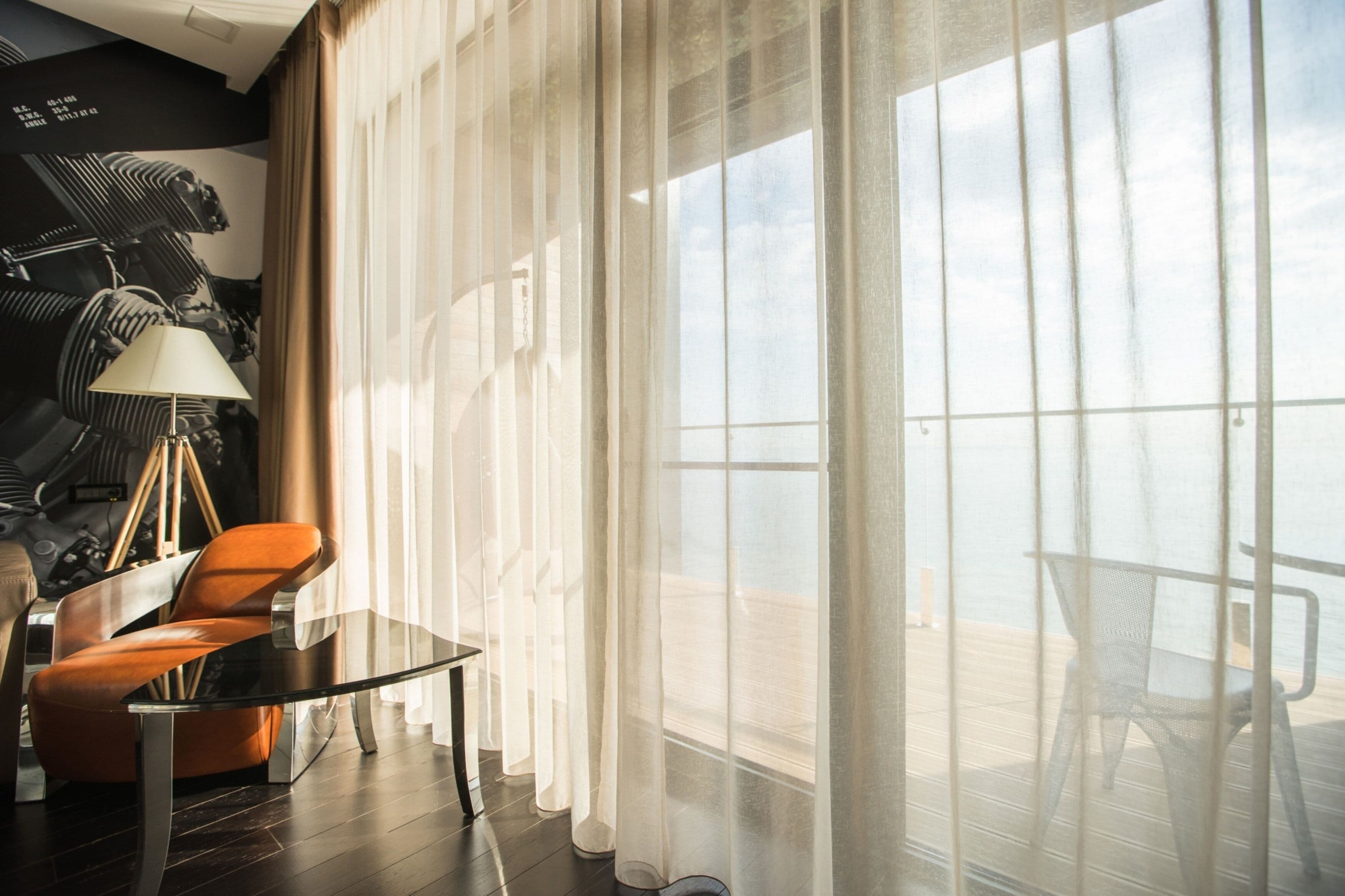 A modern room with a large window, a table, and a chair.