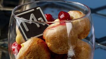 A dessert in a clear glass bowl with a cherry on top.
