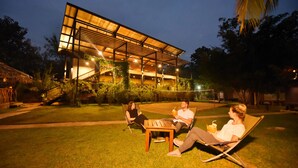 A modern building with a covered outdoor seating area. - Athgira River Camp (Udawalawa)
