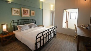 A bedroom with a bed, bedside table, lamp, and a window with curtains. - Hotel Toscana Trad (Trat)
