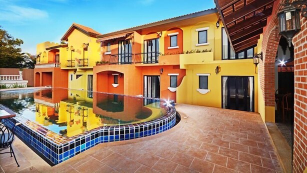 A multi-story building with a swimming pool, balconies, and a brick exterior. - Hotel Toscana Trad (Trat)