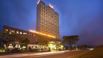 A tall hotel building with illuminated signage at the top and a well-lit entrance.