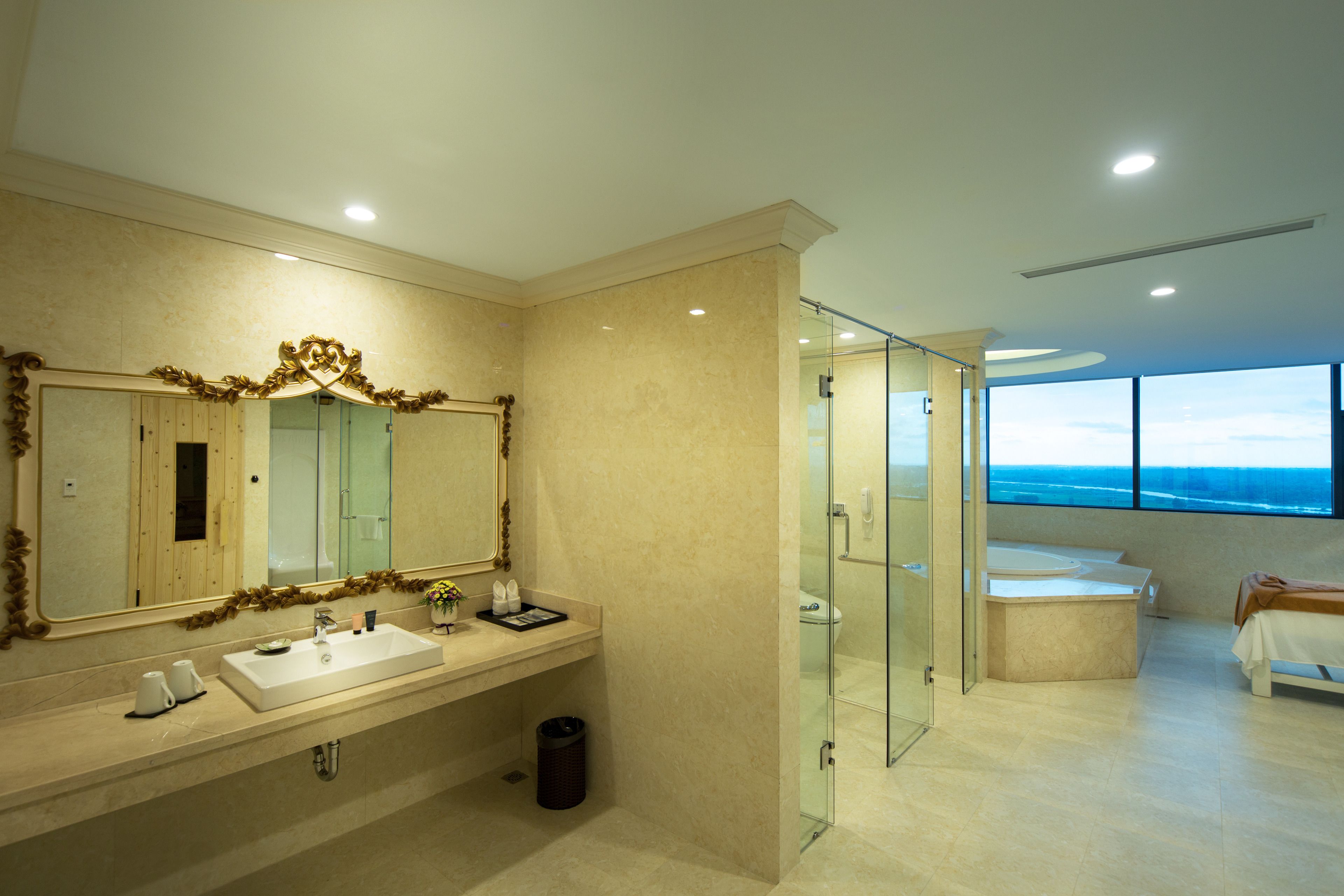 A modern bathroom with a large mirror, a sink, and a glass-enclosed shower.