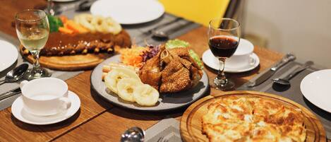 Una mesa de comedor con platos de comida, copas de vino y cubiertos.