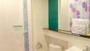 Un baño con ducha, inodoro, lavabo y espejo.