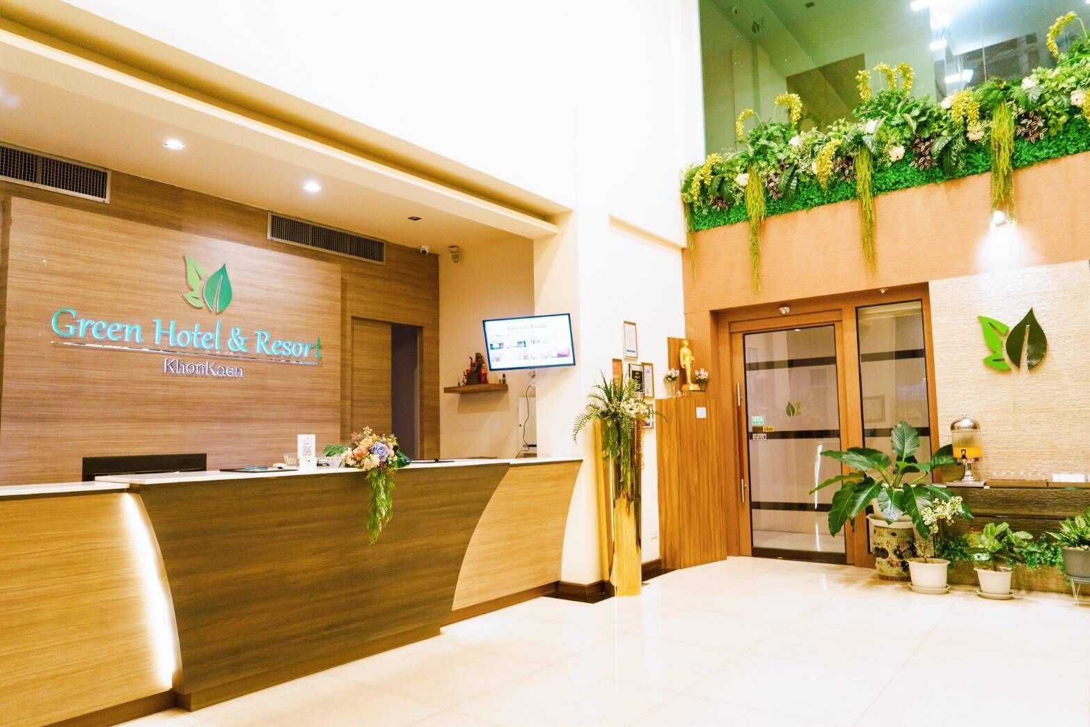 A reception desk with a wooden finish and a digital screen.