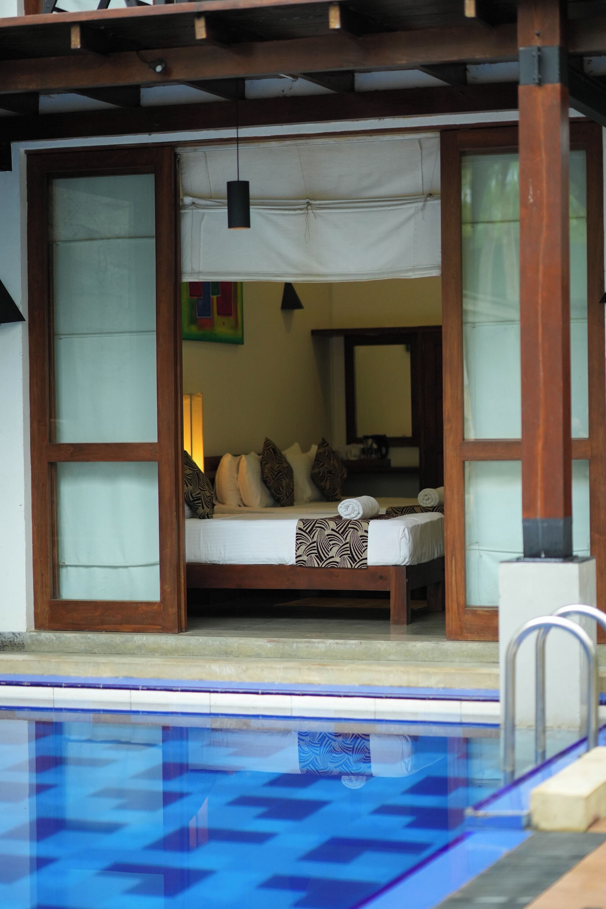 A room with a bed, a window, and a pool.