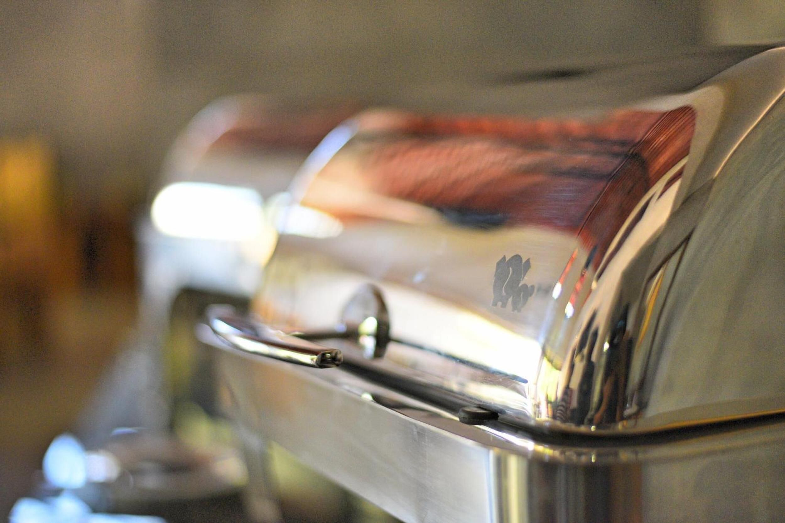 A close-up of a metallic object with a reflective surface, possibly a part of a vehicle or machinery.