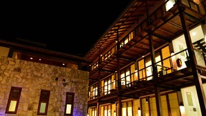 A multi-story building with a stone facade and wooden balconies. - Elephant Trail (Udawalawa)