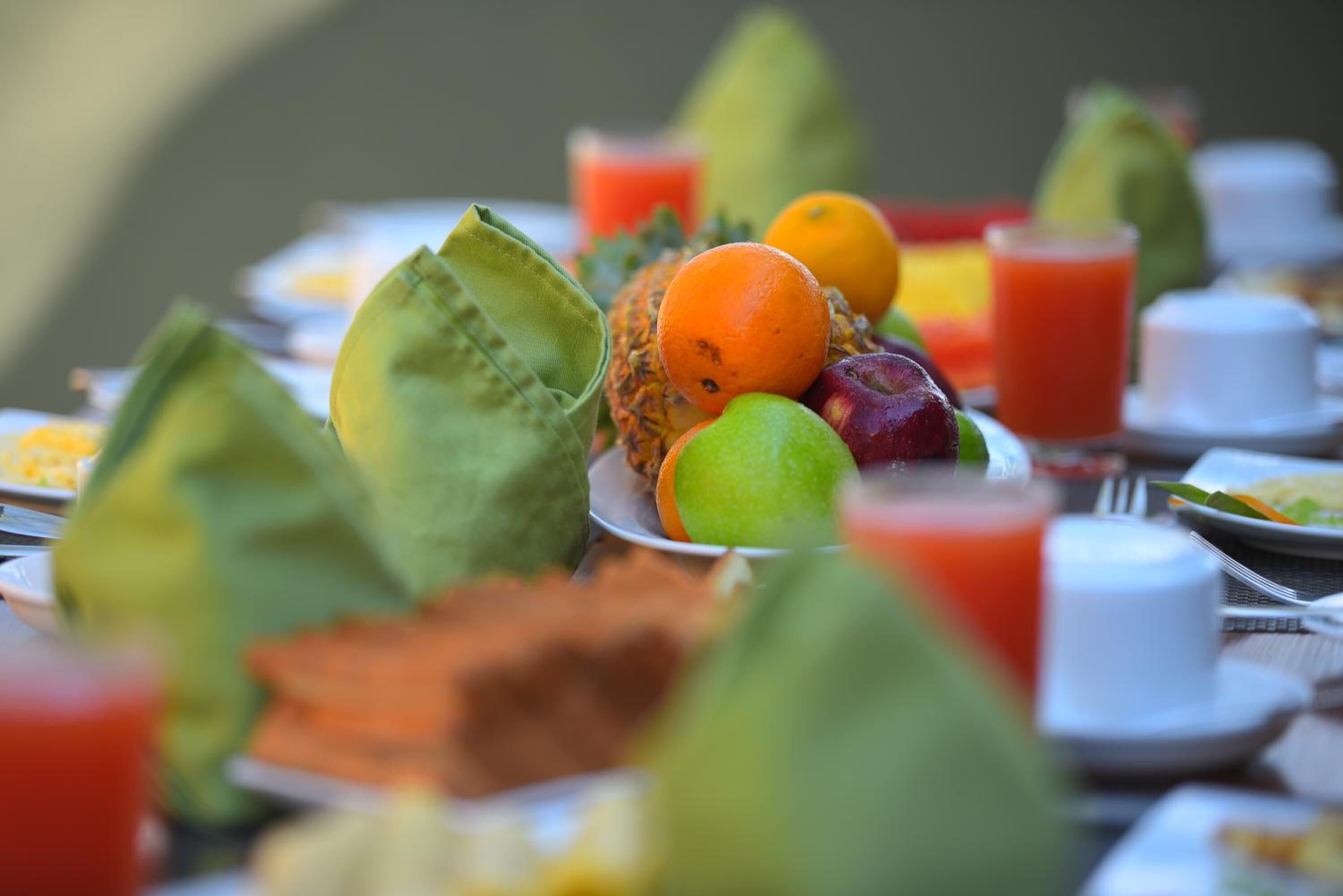 Un tavolo con diversi tipi di frutta e un bicchiere di succo.
