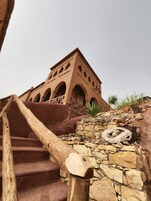 Un edificio de techo de terracota con múltiples arcos y una escalera que lo lleva hacia arriba.