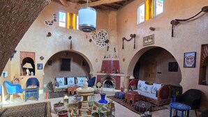 Un interior acogedor con un alto techo de madera, una chimenea y una zona de estar con sofás y sillones.