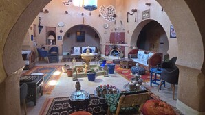 Un interior tradicional con una fuente central, zonas de estar y elementos decorativos.