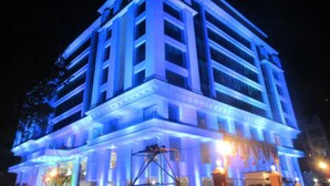 Un edificio de varios pisos con fachada simétrica, iluminado con luces azules.