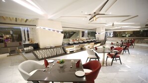 Un comedor moderno con suelo de mármol, mobiliario contemporáneo y una isla central con encimera de cocina.