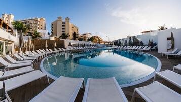 Alberca al aire libre, sombrillas en la alberca y camastros