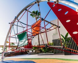 Un parque infantil con estructura de escalada y columpios.