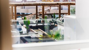 Une terrasse sur le toit agrémentée d’une pergola en bois, de plantes en pot et d’un petit élément décoratif aquatique.