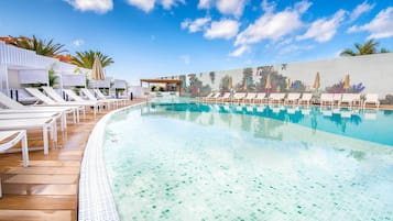 Alberca al aire libre, sombrillas en la alberca y camastros